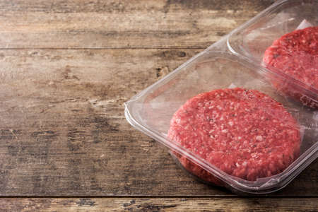 burger meat packaged in plastic on wooden table. Copy spaceの写真素材