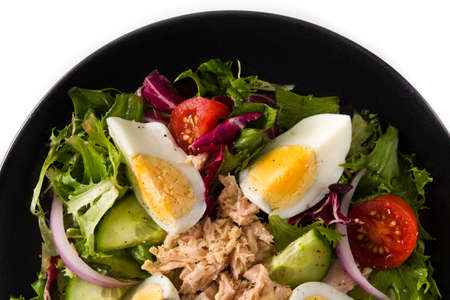Salad with tuna, egg and vegetables isolated on white background. Top view