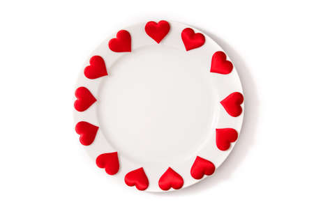 White plate surrounded by hearts on white backgroundの写真素材