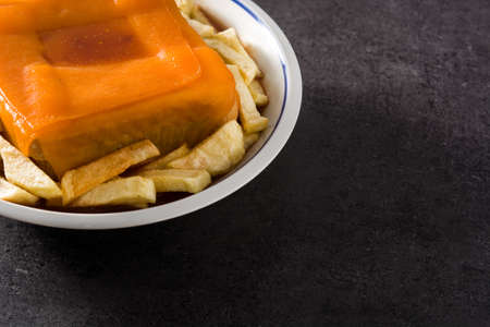 Typical Portuguese francesinha sandwich with french fries on black background copy spaceの写真素材
