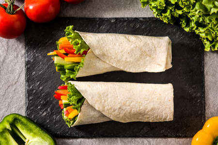 Vegetable tortilla wraps on gray stone background. Top viewの写真素材