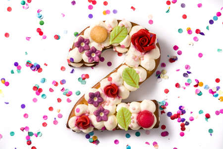 Number two cake decorated with flowers, macarons and confetti isolated on white background.の写真素材