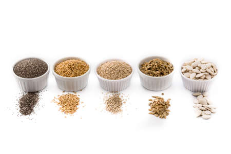 Assortment of different seeds in bowl isolated on white background. Pumpkin, linen, chia, sunflower,...