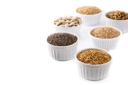 Assortment of different seeds in bowl isolated on white background. Pumpkin, linen, chia, sunflower,...