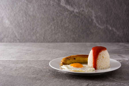 Cuban rice Typical Cuban rice with fried banana and fried egg on gray background copy space