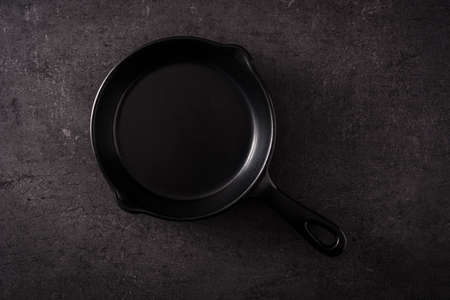 Iron frying pan empty on black slate backgroundの写真素材