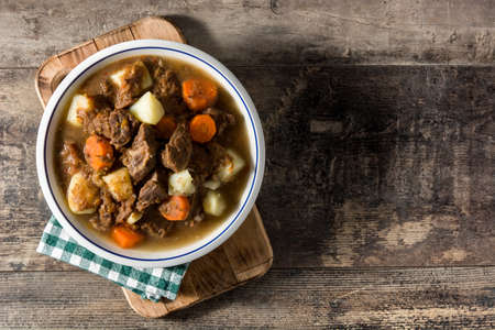 Irish beef stew with carrots and potatoes on wooden tableの写真素材