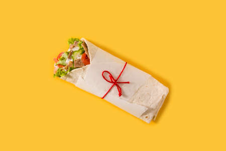 Doner kebab or shawarma sandwich isolated on yellow backgroundの写真素材