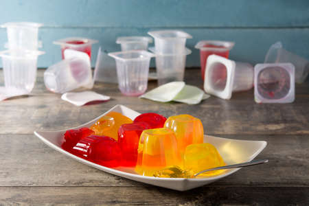 Jellies of different flavors on wooden background