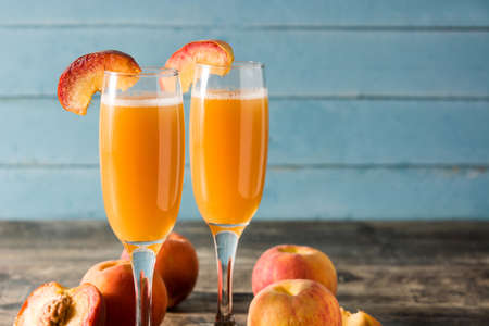Bellini champagne cocktail in crystal glass on wooden tableの写真素材