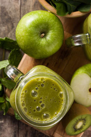 Healthy green smoothie in jar on wooden tableの写真素材