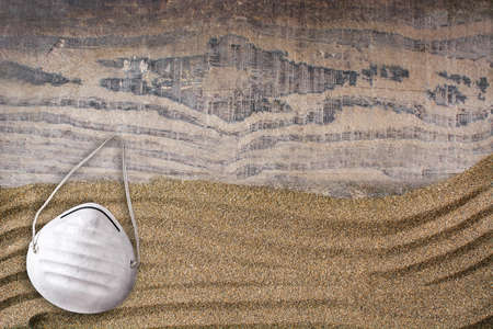 Protective face mask on sand background, Copyspace.