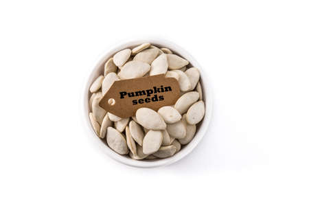 Pumpkin seeds in bowl isolated on white background.