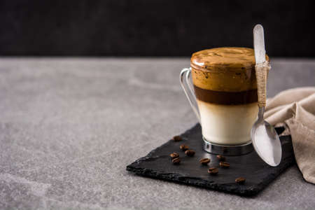 Creamy iced dalgona coffee on gray stone backgroundの写真素材