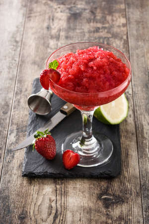 Strawberry margarita cocktail in glass on wooden table.の写真素材