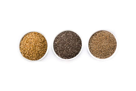 Assortment of different seeds in bowl isolated on white background. Linen, chia and sesame seeds isolated on white backgroundの写真素材