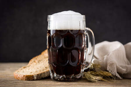 Traditional kvass beer mug with rye bread on wooden tableの写真素材