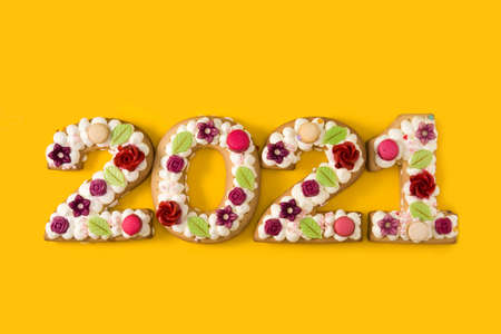 2021 cake and ornaments isolated on yellow background. New year concept.の写真素材