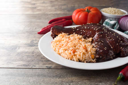 Traditional mole Poblano with rice in plate on wooden tableの写真素材