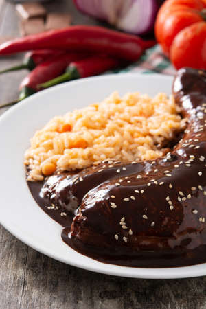 Traditional mole Poblano with rice in plate on wooden tableの写真素材