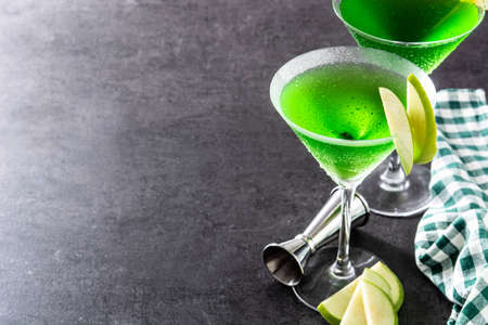 Green appletini cocktail in glass on black background.の写真素材