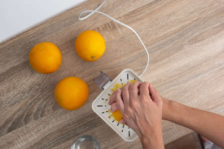 Woman squeezing oranges in the kitchen