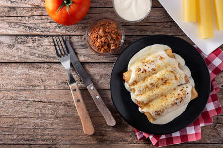 Delicious meat cannelloni pasta on rustic wooden table