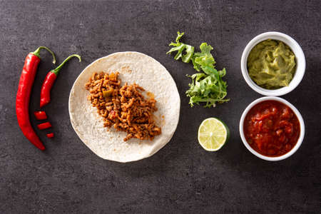 Mexican tacos ingredients on black stoneの写真素材