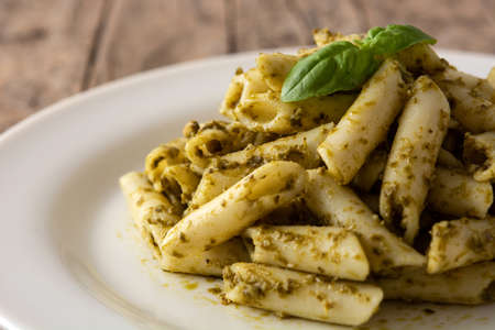 Penne pasta with pesto sauce on wooden tableの写真素材