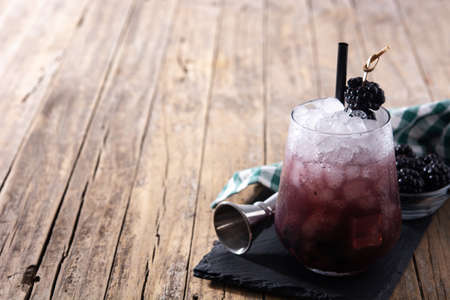 Fresh blackberry cocktail in cold glass on wooden tableの写真素材
