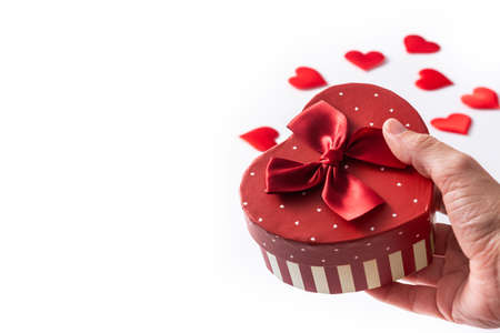 Female hands holding a gift box with heart shape for Valentine's Day