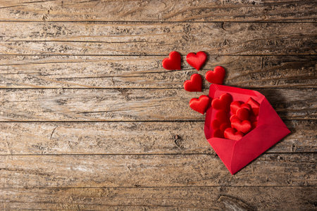 Hearts coming out of an red envelope on rustic wooden table. Top view. copy space. Valentines day conceptの写真素材