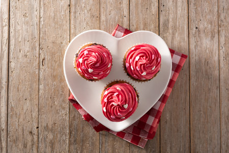 Cupcakes decorated with sugar hearts for Valentine's Day on wooden tableの写真素材