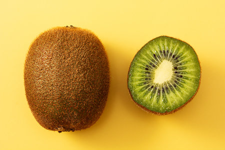Fresh kiwi on yellow backgroundの写真素材