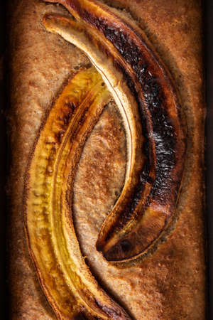 Homemade banana bread on rustic wooden table.の写真素材