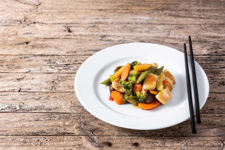 Stir fry chicken with vegetables on rustic wooden tableの写真素材
