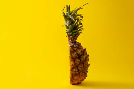 Sliced pineapple on yellow background. Copyspace