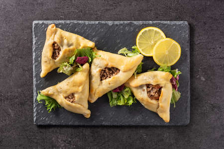 Traditional middle eastern fatayer on black slate background