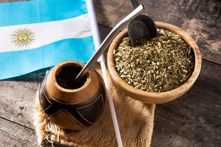 Yerba mate tea and Argentina flag on wooden table. Traditional Argentinian beverageの写真素材