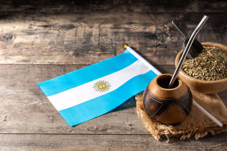 Yerba mate tea and Argentina flag on wooden table. Traditional Argentinian beverageの写真素材