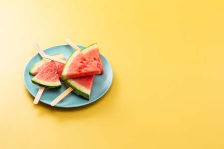 Watermelon slices ice lolly on yellow background