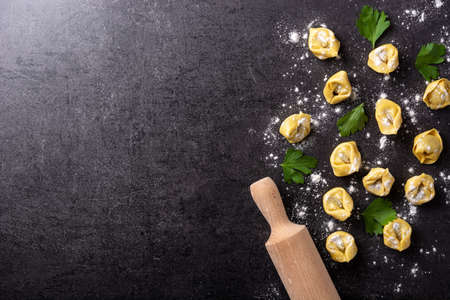 Uncooked pelmeni dumplings on black background. Top view. Copy spaceの写真素材