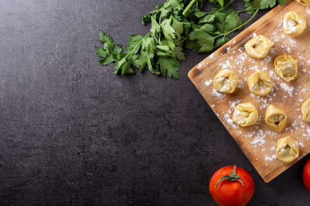 Uncooked pelmeni dumplings on black background. Top viw. Copy spaceの写真素材