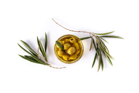 Virgin olive oil and olives in a crystal bowl on white background. Top view