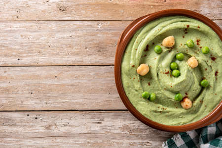 Green pea hummus and pita bread on wooden tableの写真素材
