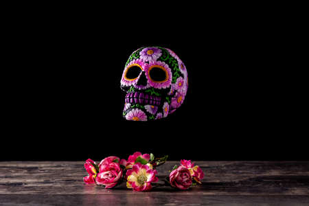 Typical Mexican skull and flowers diadem on black background. Day of the Dead.