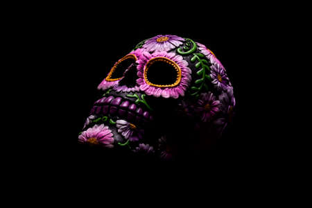 Typical Mexican skull with flowers painted on black background. Day of the Dead.の写真素材