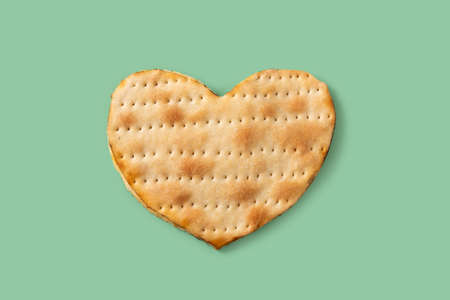 Heart shaped matza bread on green backgroundの写真素材