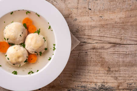 Traditional Jewish matzah ball soup on wooden tableの写真素材