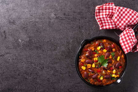 Traditional mexican tex mex chili con carne in iron pan on black stone backgroundの写真素材